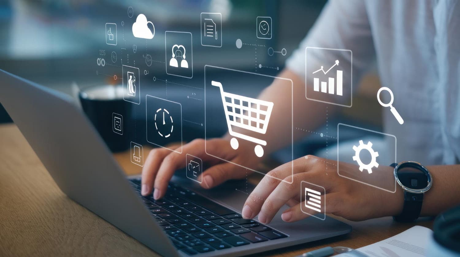 Osoba pracująca na laptopie z holograficznymi ikonami e-commerce, przedstawiającymi koszyk zakupowy, wykresy analityczne i ustawienia techniczne.
